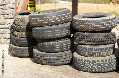 Stack of used car tires outdoors.