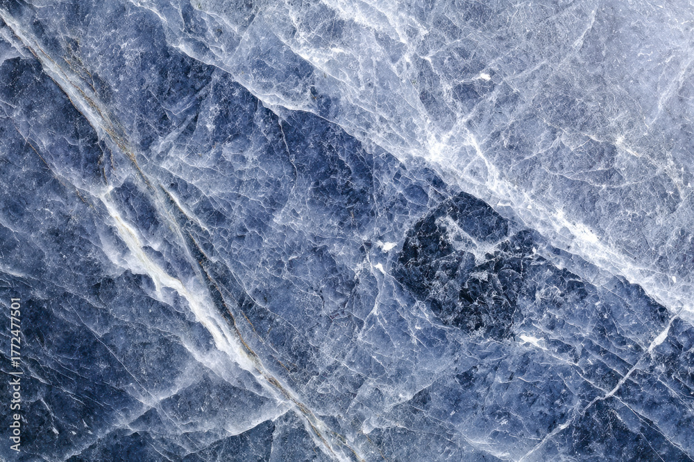 Obraz premium Deep blue natural stone surface with intricate white veining and textured crystalline patterns creating a stunning mountainous rock appearance background