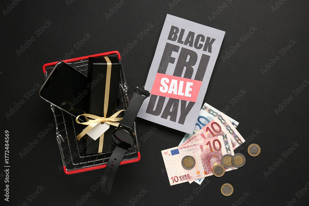 Obraz premium Greeting card with text BLACK FRIDAY SALE, shopping basket, gifts, credit cards and money on dark background