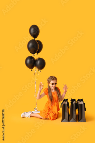 Little girl with balloons a...