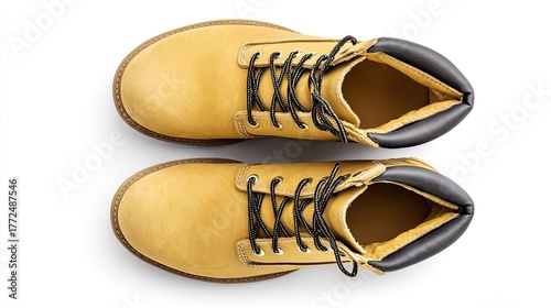 A pair of yellow lace up work boots are displayed from a top down view.