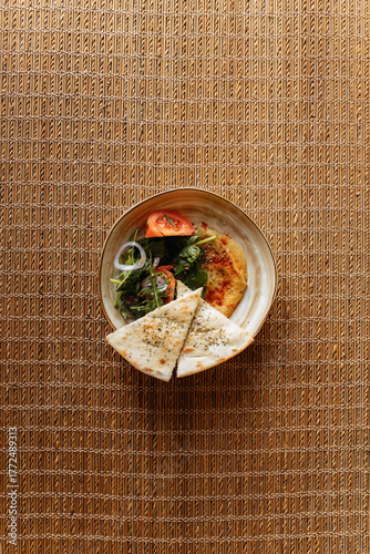 Salad with vegetables and traditional bread on a bamboo background