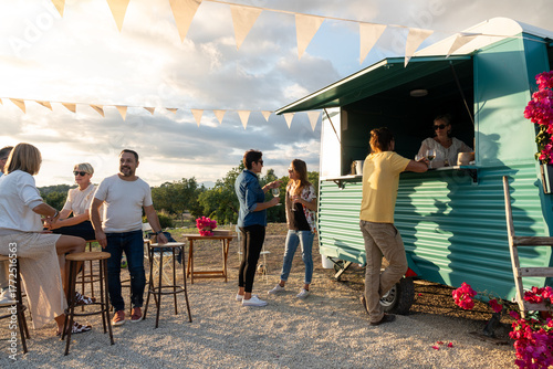 Friends enjoying drinks at outdoor food truck party