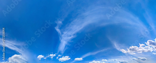 Panorama blue sky with white fluffy clouds. Copy space on panorama of cumulus and cirrus arc clouds drifting calmly across the sky toward the viewer. A majestic spectacle of nature's elements.