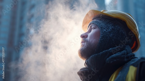 Construction worker in cold weather exhaling steam, wearing a hard hat