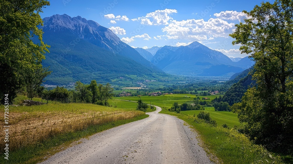 Fototapeta premium Winding gravel road leads to scenic mountain valley.