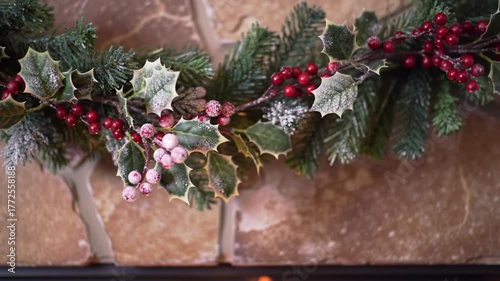 Festive Christmas Garland With Red Berries And Evergreen Branches Draped Over A Textured Stone Fireplace