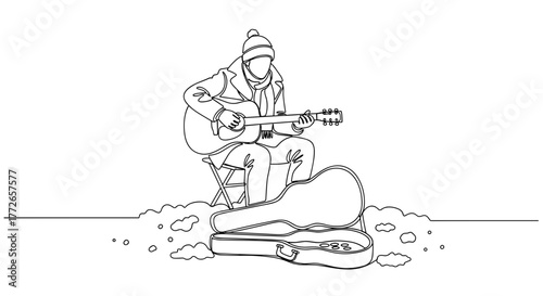 Young man playing guitar while sitting on chair outdoors in winter  