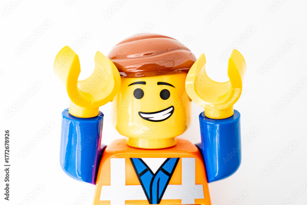 Obraz premium Bradford, UK Oct 30 2025 - Lego Emmet plastic toy shot close up on a white background. Both arms raised in a look of surprise