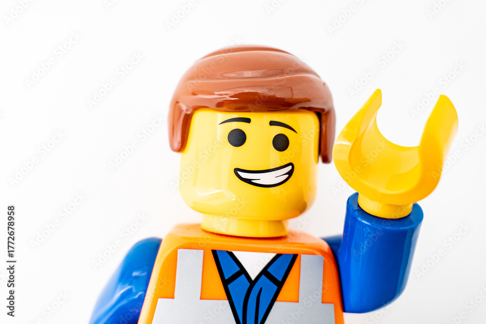 Obraz premium Bradford, UK Oct 30 2025 - Lego Emmet plastic toy shot close up on a white background. With one arm raised in greeting.