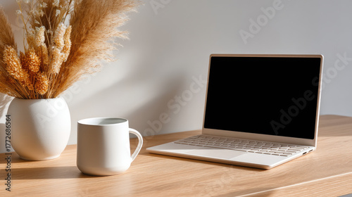 Minimal home workspace with laptop on beige wooden desk, soft daylight, ceramic cup, pampas grass, clean lifestyle branding header, neutral tones
