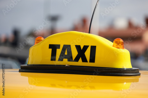 Canvas Print An illuminated taxi sign mounted on the roof of a car