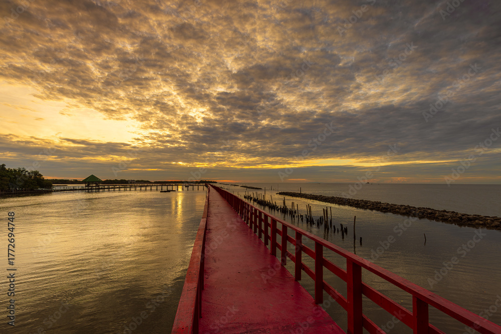 Obraz premium Red wooden bridge in Samut Sakhon Province, a popular tourist attraction in Samut Sakhon Province, Thailand 