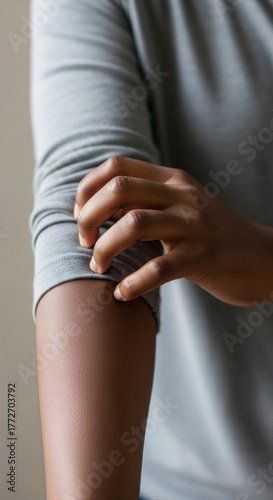 African American woman scratching her itchy arm. Vertical template of skin irritation common symptom of diabetes or allergic reaction. Healthcare and dermatology concept.