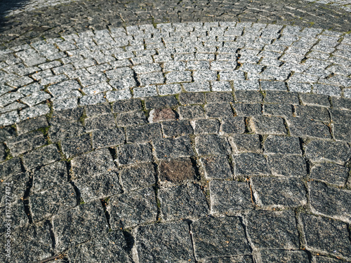 Billede på lærred A close-up of gray granite pavers laid in a semicircular arc