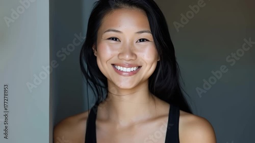 Beautiful young asian model woman with straight black brunette hair smiling to camera in slow motion video.Zoom out.AI Generative.