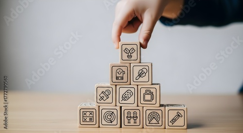 Hand stacking wooden blocks with business and finance icons