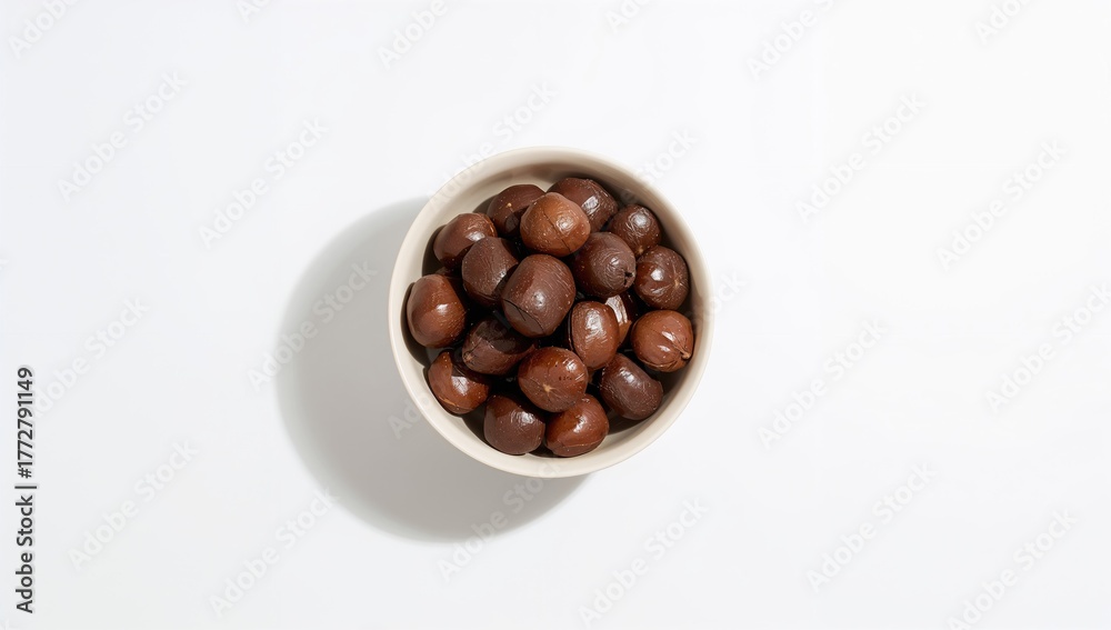 Fototapeta Brown chestnuts arranged in a bowl on a light background, fiber-dense choice