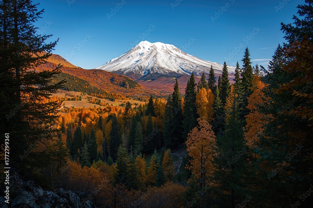 Fototapeta premium A mountain summit covered in snow surrounded by vibrant autumn foliage, creating a breathtaking blend of seasonal contrasts.