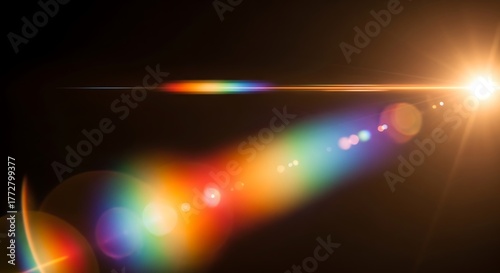 A bright light with a rainbow colored lens flare against a dark background in a horizontal shot