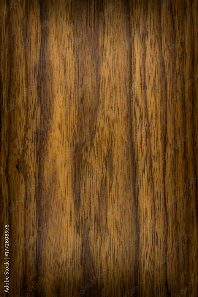 Obraz premium wooden background, board surface, natural wood dark brown pattern, american valnut, vignetting, frame with a place for text or object, vertical