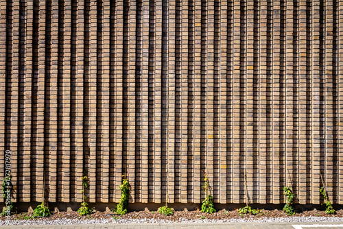 Brown modern brick wall background with some plants
