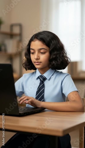 Focused Indian Schoolgirl Working on a Laptop at a Desk in a Home Setting generative ai
