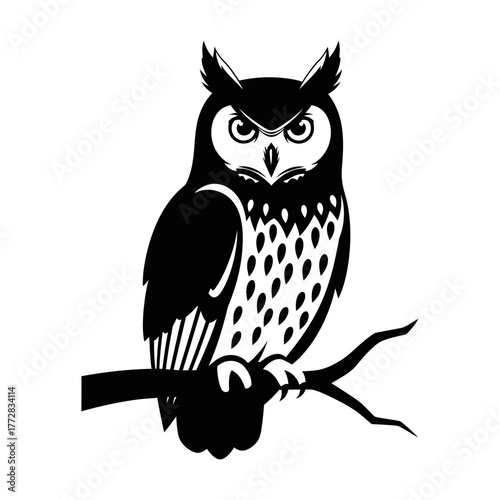 Majestic owl perched on a branch, observing with intense focus.