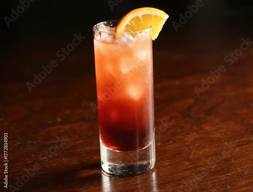Refreshing layered cocktail with ice and a lemon slice garnish