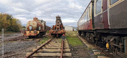 Foto Old fashioned locomotive steam engines, train carriages, rusting railroad tracks
