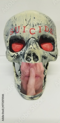 SCULPTURE: A human skull with glowering red eyes and emblazoned with red letters above the brow spelling the word 