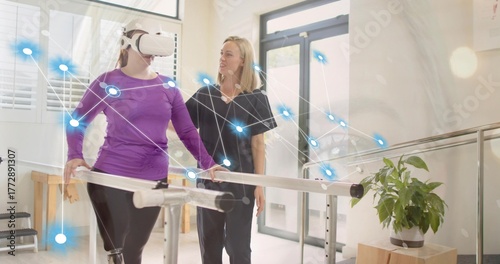 Gripping bars patient wearing VR headset receiving therapist aid in rehab with network overlay