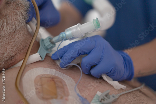 Patient receiving medical care with tracheostomy and ventilator