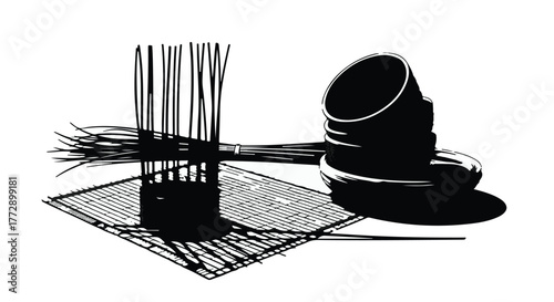 Abstract arrangement of dark straws and a cup casting sharp shadows on a white surface