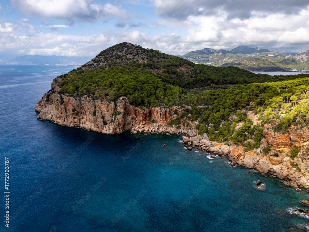Fototapeta premium Turquoise blue Mediterranean sea washing rocky shore, Antalya, Turkiye