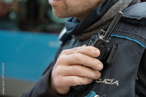 Police officer holding radio transceiver during patrol