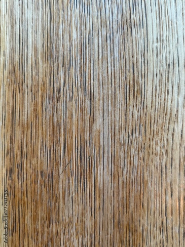 Wooden table surface with natural grain and warm texture. Rustic wood background ideal for food, product, or lifestyle design concepts. Vertical board or table