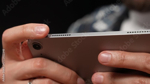 Moscow, Russia - March 23, 2025: hands holding a modern tablet with focus on details