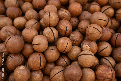 Close-up of unshelled macadamia nuts with natural patterns
