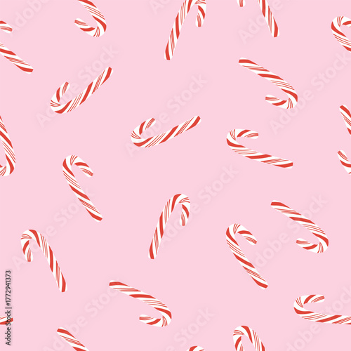 Tossed candy canes on pink seamless pattern. Simple Christmas background. Cute minimalist holiday design for wrapping paper, fabric, wallpaper.