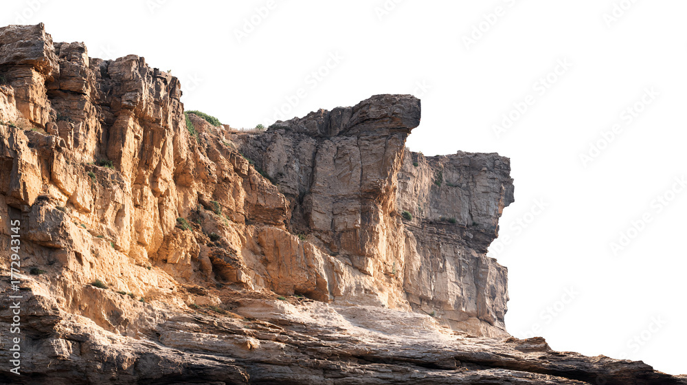 Fototapeta premium Dramatic rocky cliff face illuminated by golden sunlight against a dark sky