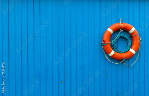 Orange and blue. Wooden wall with a lifesaver