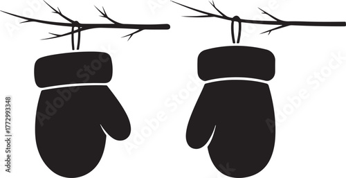 Two silhouette mittens hanging from bare winter tree branches