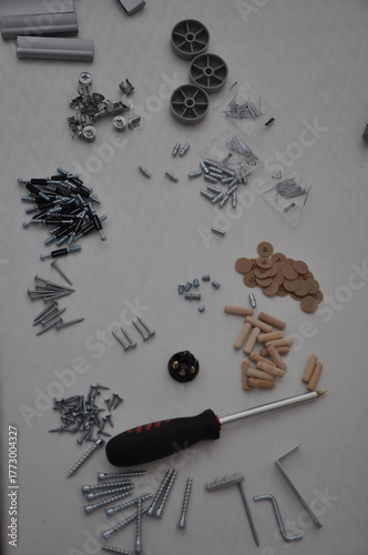 Furniture assembly. Group of furniture parts placed on white table. Cabinet assembly tool. Top view of various furniture fittings. Furniture assembly kit