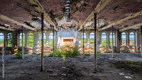 Derelict disused factory collapsing. Abandoned old industrial warehouse, peeling paint, dark shadows, bright sunlight through broken windows. Post-apocalyptic disaster scene, crumbling building ruins