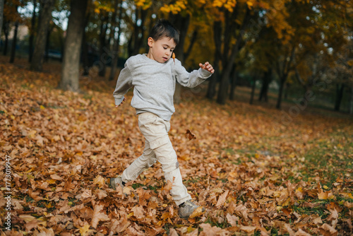 Canvas Print youth vaults over crunchy foliage, boy energetically jumping through colorful au