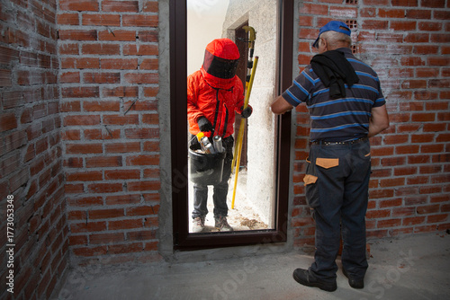 A pest control technician removes an Asian hornet (Vespa velutina) nest from a house under construction in Meis, Galicia.