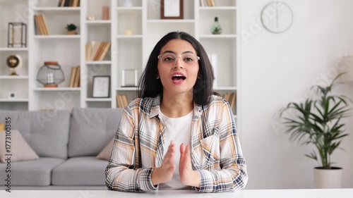 An Indian girl student is listening to a webinar in an online class at a college. Beautiful young woman talking on a video call smiling. Studying in quarantine, listening to a podcast, camera view.