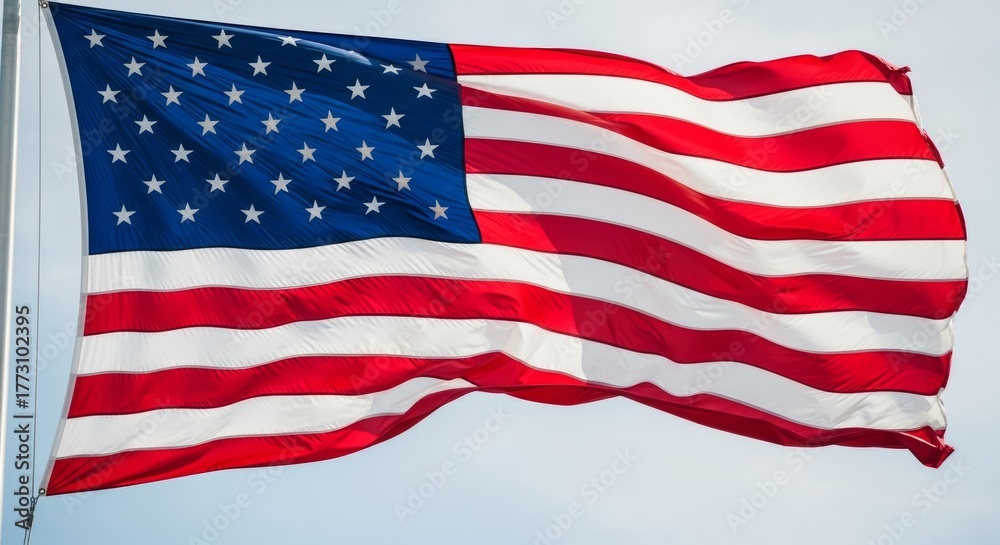 Fototapeta premium Waving american flag against blue sky on a windy day