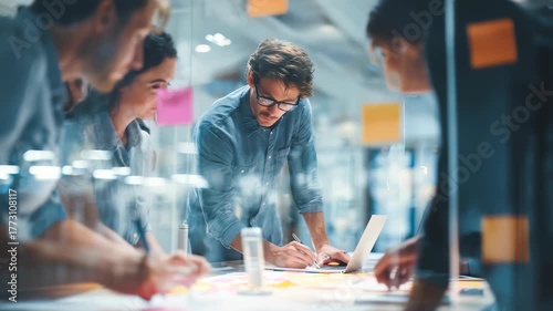 Young professionals gather around a table in a contemporary workspace, actively discussing and developing new concepts. Teamwork and creativity drive their productive business meeting